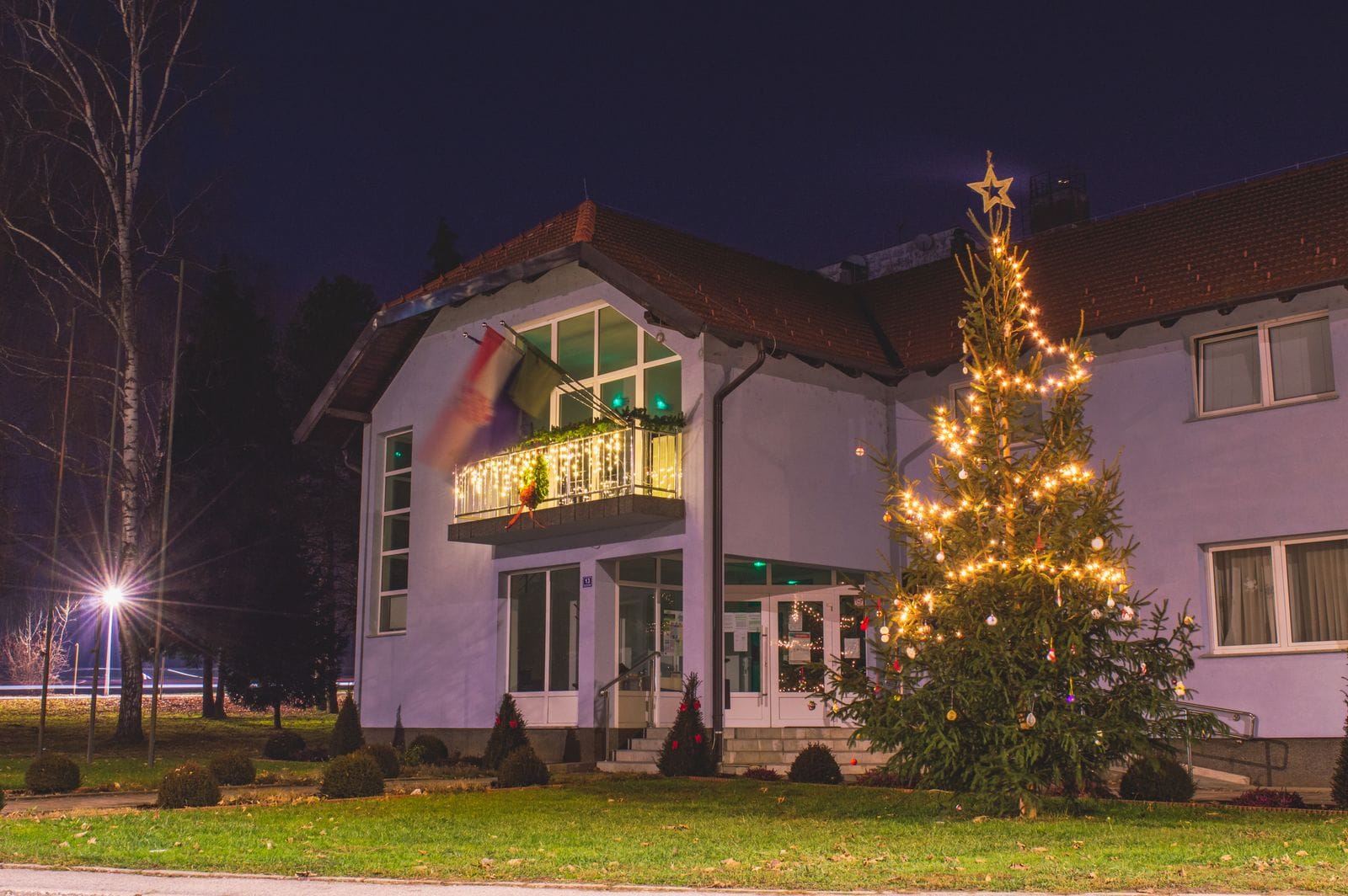 Home with roofline lights and a lit outdoor tree